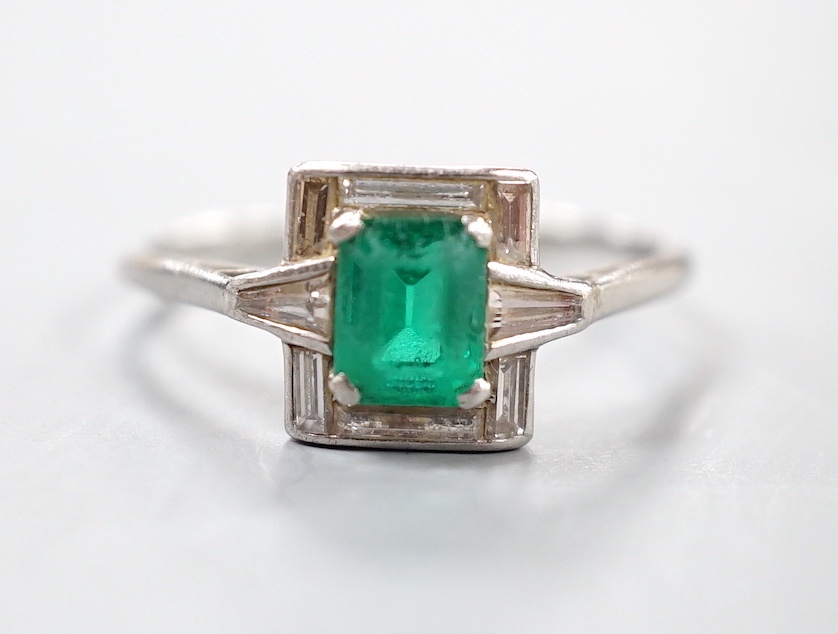 An Art Deco white metal, single stone emerald, baguette and trapeze cut diamond cluster set ring, size R/S, gross 3.5 grams